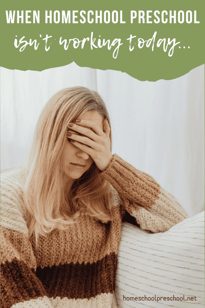 Homeschool mom sitting on a couch with her hand covering her face, looking overwhelmed during a rough preschool day at home.