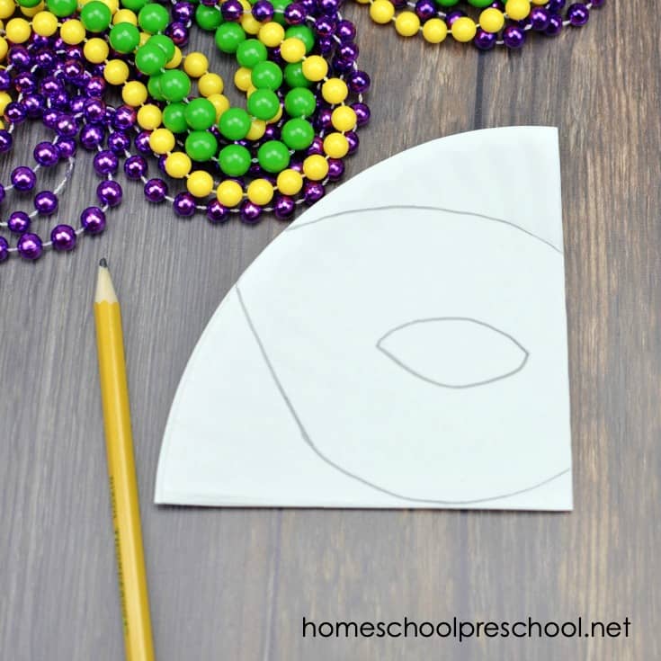 You don't want to miss this festive Mardi Gras paper plate craft for kids! Come see how to turn a paper plate into a fun beaded Mardi Gras mask for kids to wear!