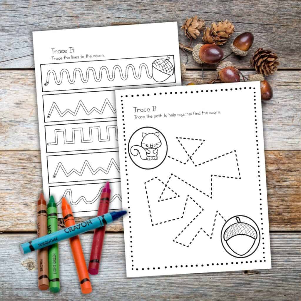 Printable preschool tracing worksheets with acorn and squirrel themes, featuring crayons on a wooden surface with acorns nearby.