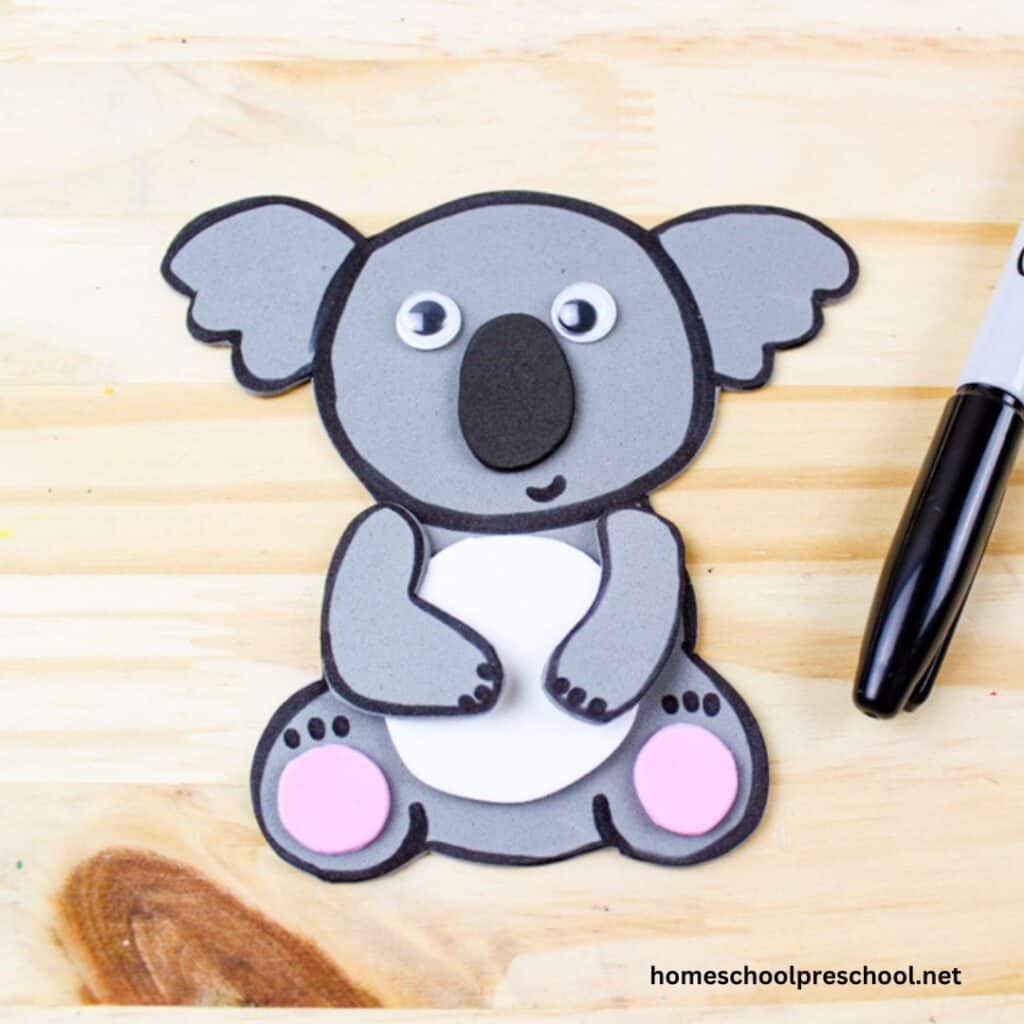 koala paper craft and black sharpie on plywood background