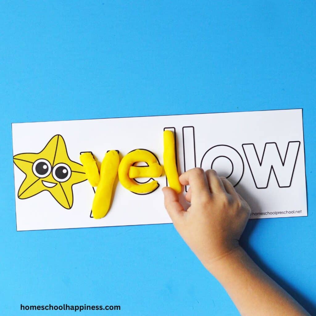 child's hand, yellow playdough, spelling the word yellow