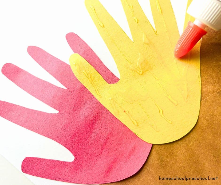 gluing hands on construction paper logs