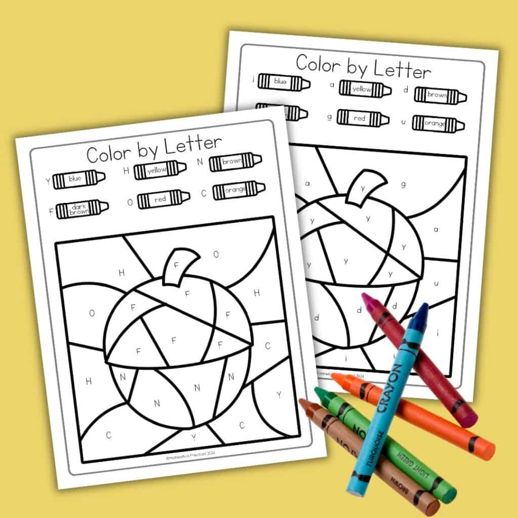 Two acorn-themed color by letter worksheets with color key on yellow background. Uncolored, with five crayons placed in front.
