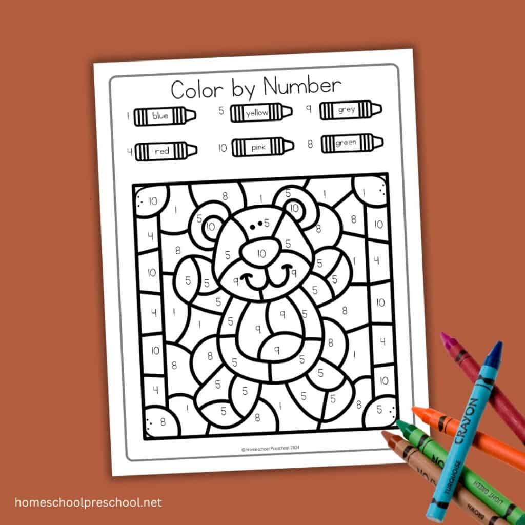Teddy bear color by number worksheet featuring numbers 1-10, with color code crayons and a stack of crayons on the side.